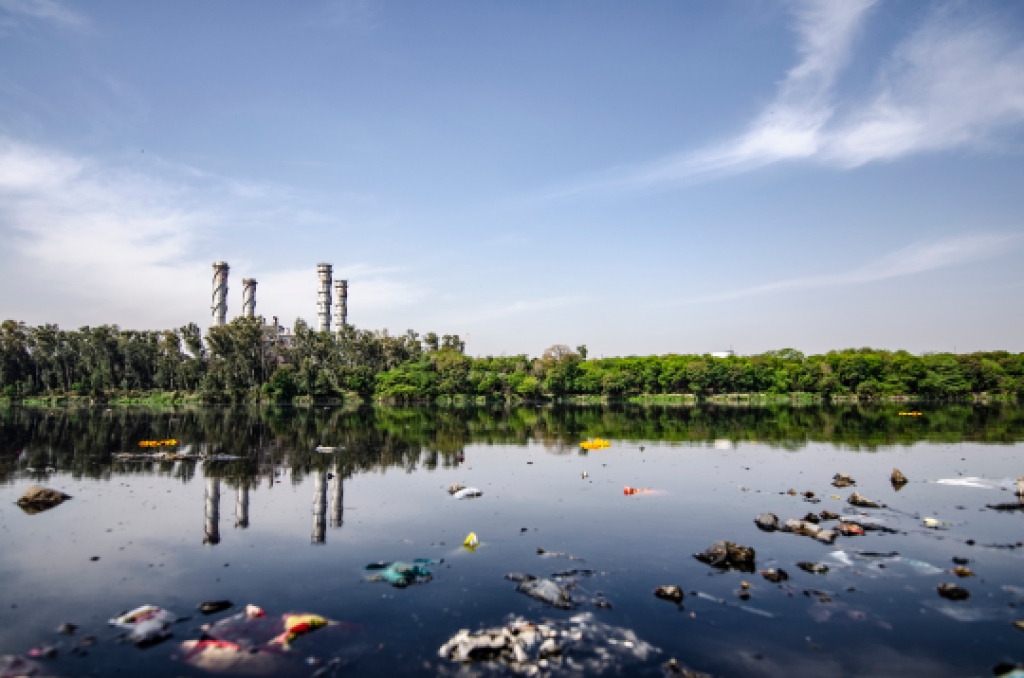 A water body is seen polluted by industrial waste